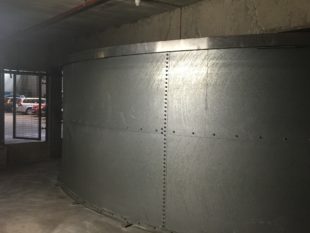 This Franklin Hodge sprinkler water tank in London was leaking from all the wall panel joints and bottom corner because the butyl rubber 'bag' liner was holed and letting the water behind it.